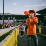 sports fan playing vuvuzela near stadium